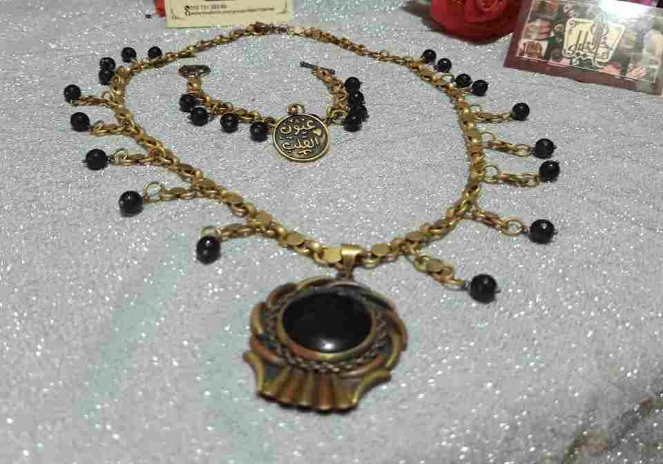Two-piece Copper set, a yellow and red copper pendant with a black agate clove and black agate beads, a copper chain, a copper bracelet and knot beads