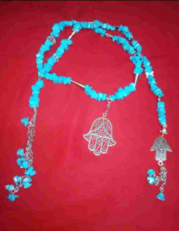 A turquoise fracture necklace with metal palm pendants