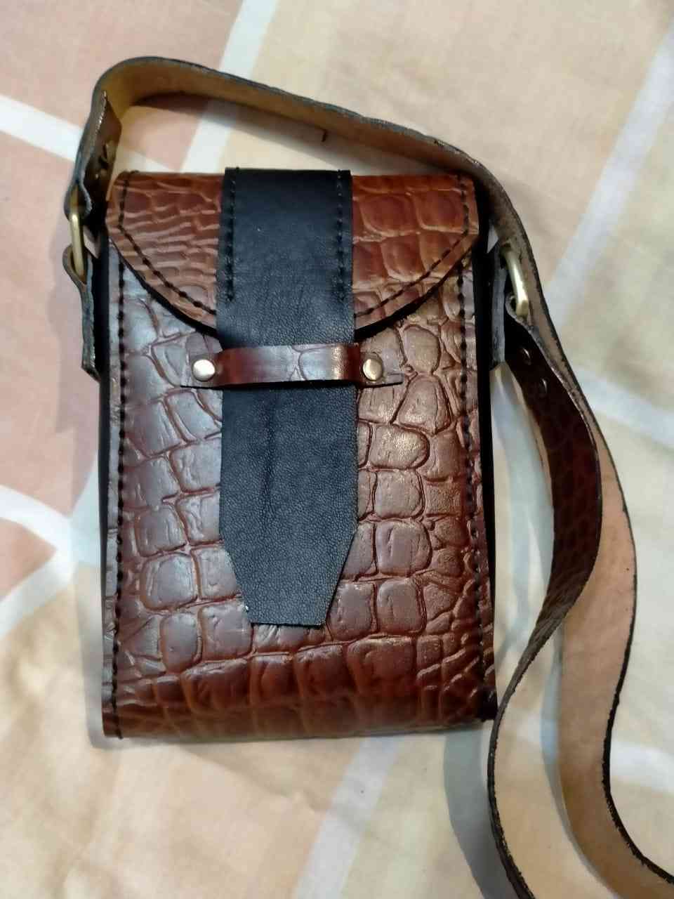 Genuine cowhide leather mobile bag with crocodile print on it and lined from the inside with pockets