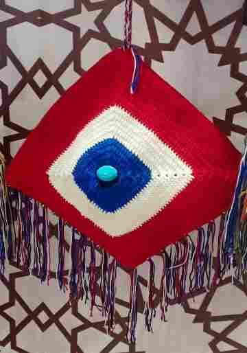 Crochet eye-shaped portafé made of cotton, lined with a zipper and a crochet shackle